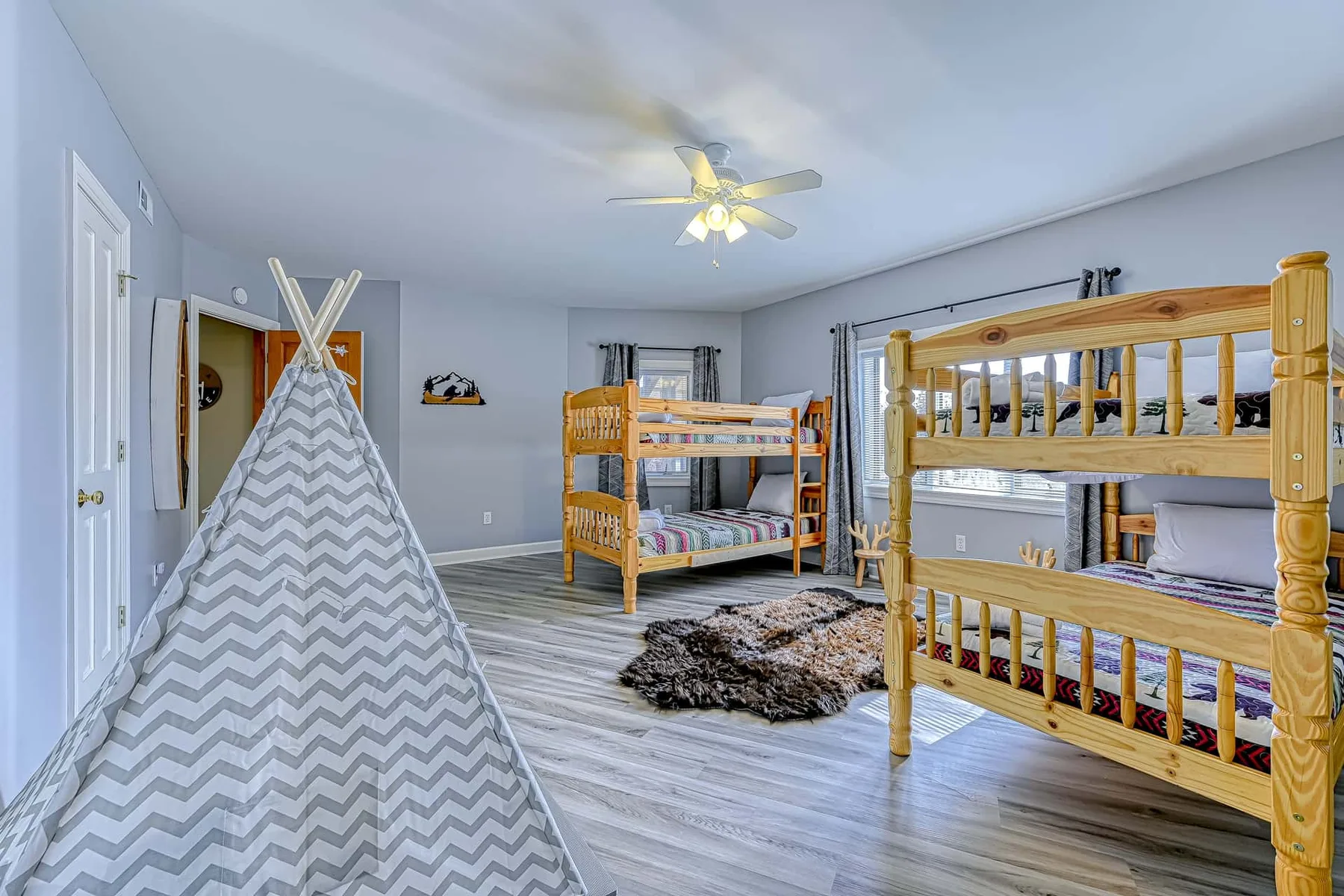 Un dormitorio con literas de madera y una tienda de juegos estampada.