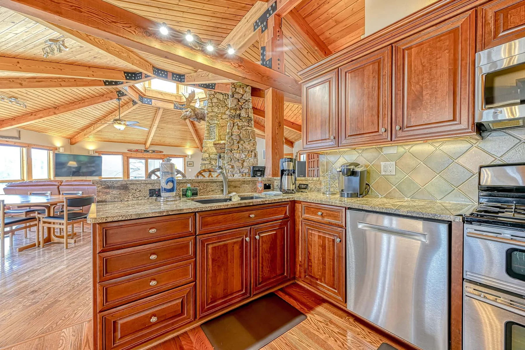 Una cocina revestida de madera con una encimera de piedra y electrodomésticos de acero inoxidable.