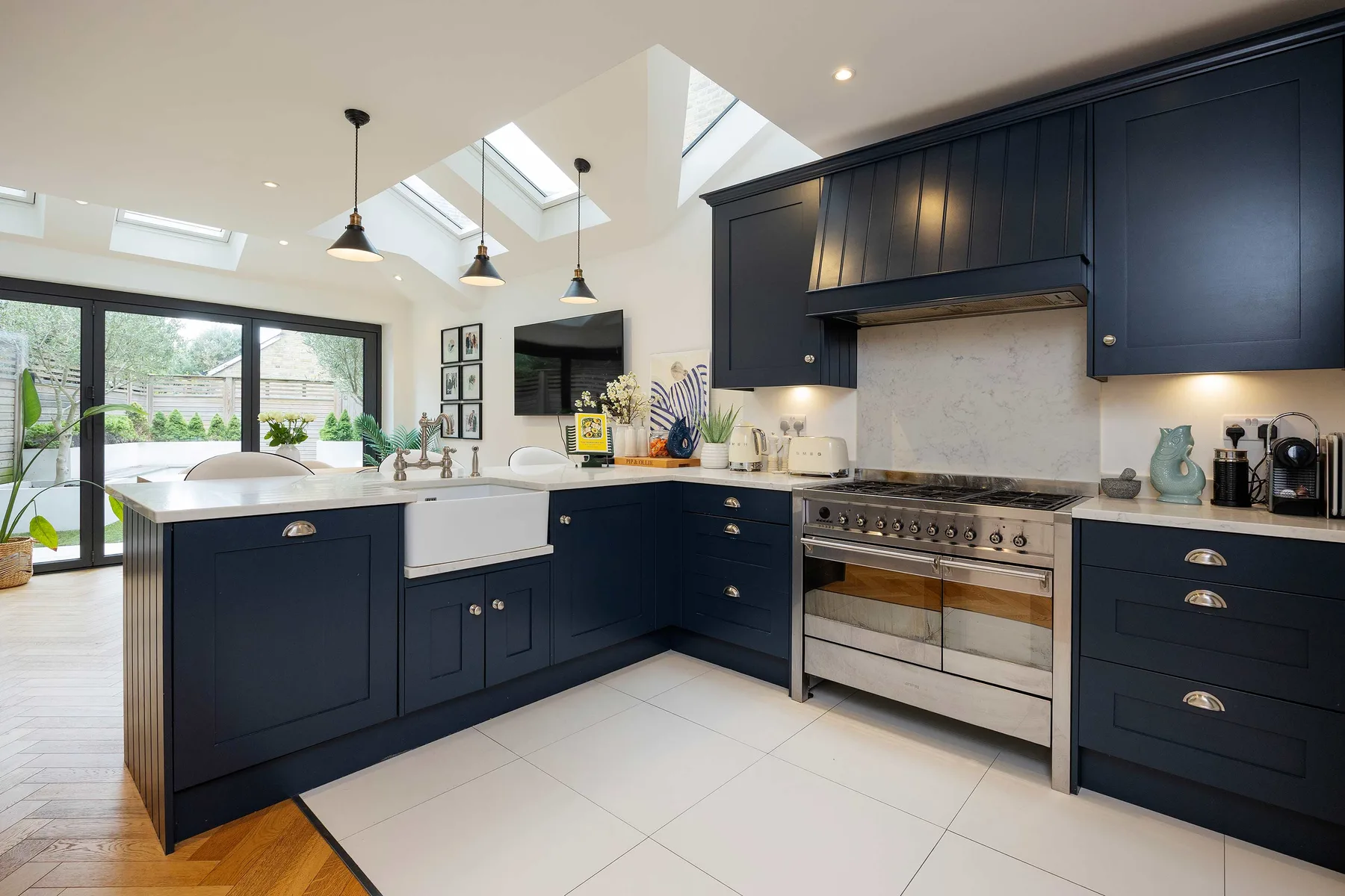 A bright modern kitchen with dark cabinetry, a central island, and skylights.