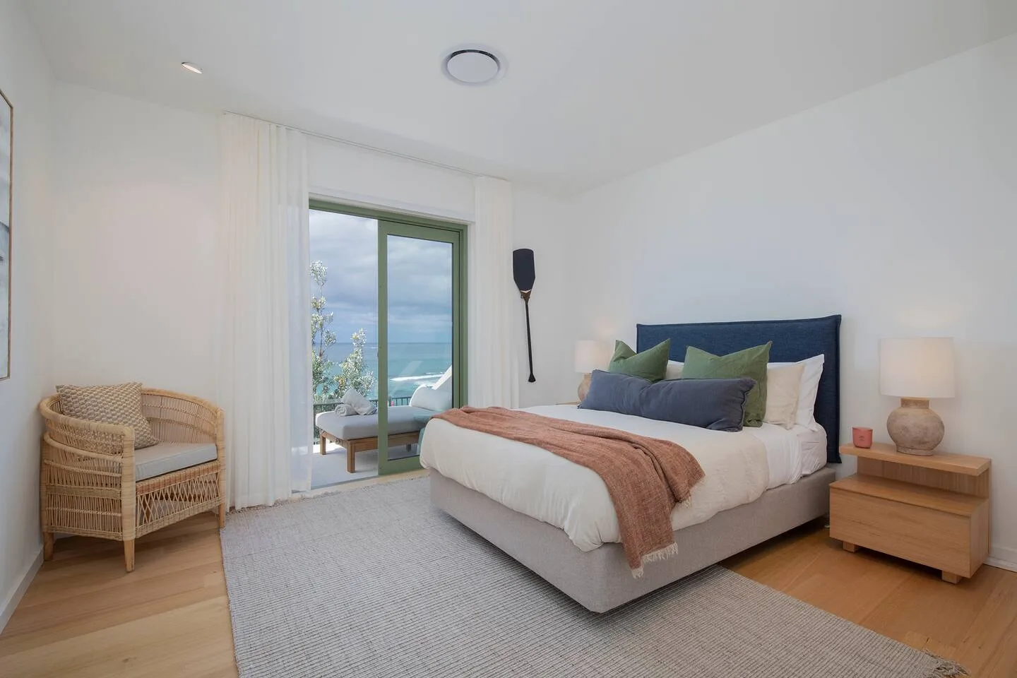 Un dormitorio con una cama y puertas corredizas de vidrio que dan a un balcón.