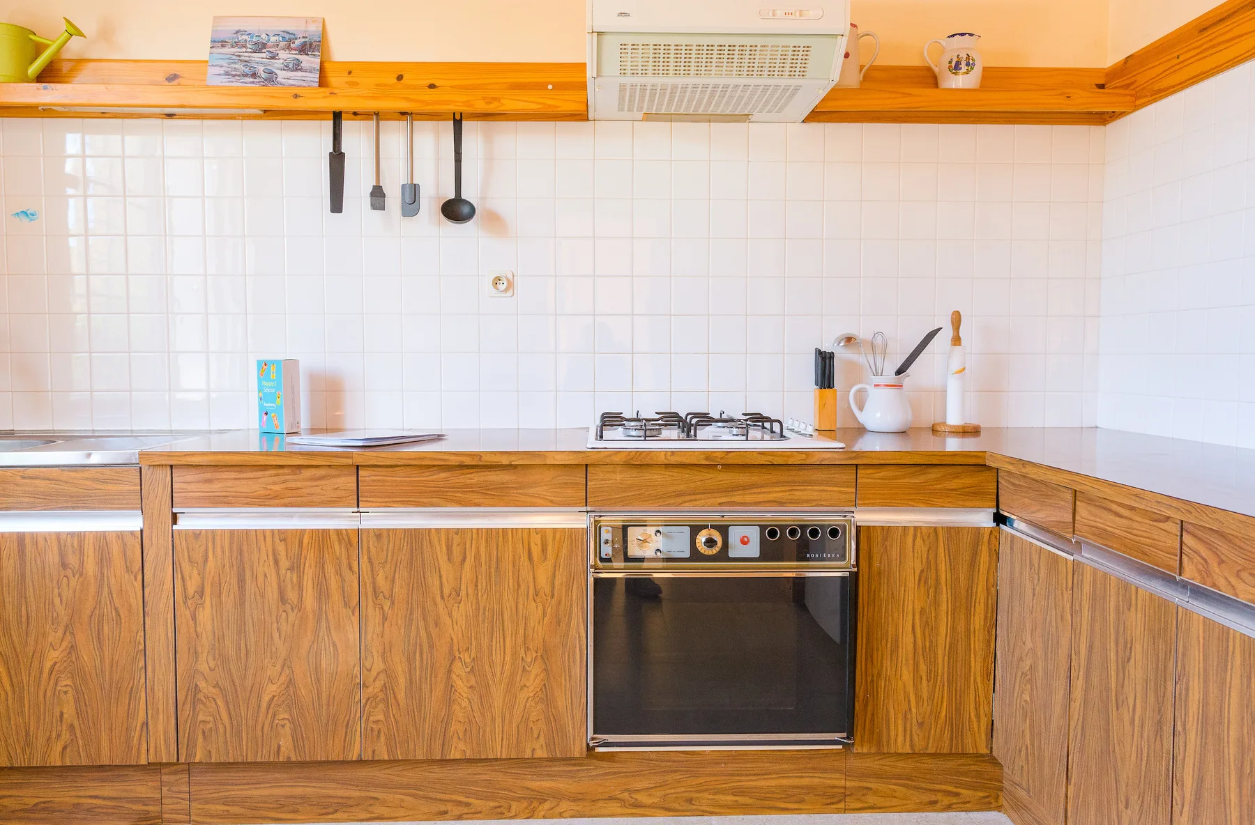 A kitchen with wood cabinetry, a cooktop, and an oven.