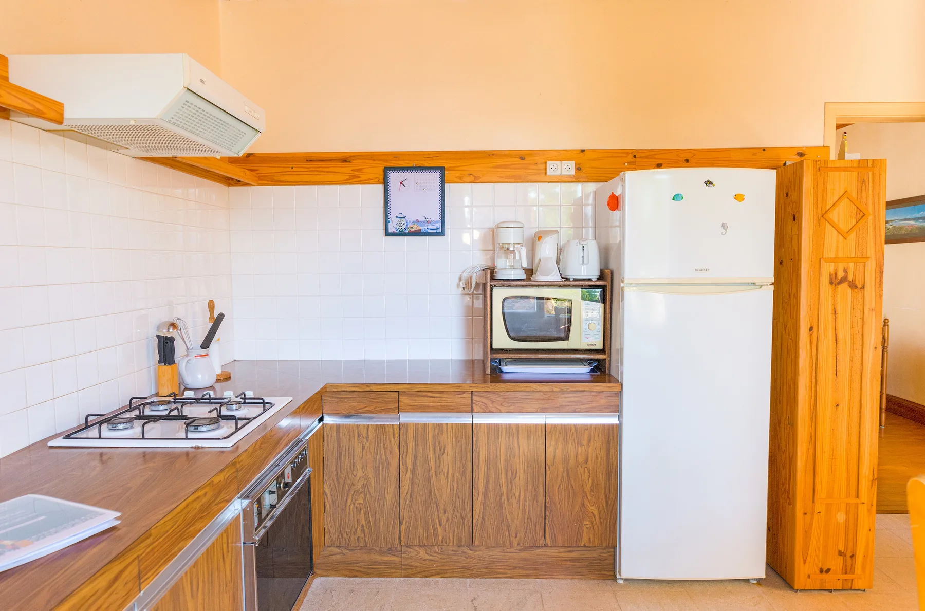 A kitchen with wooden cabinets, a stove, and a refrigerator.
