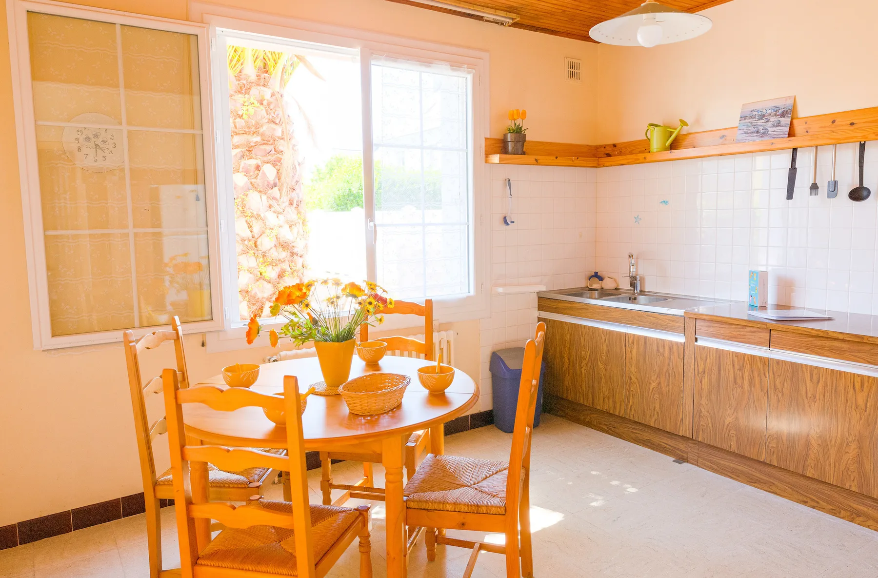 A bright kitchen with a wooden dining table beside the counter.