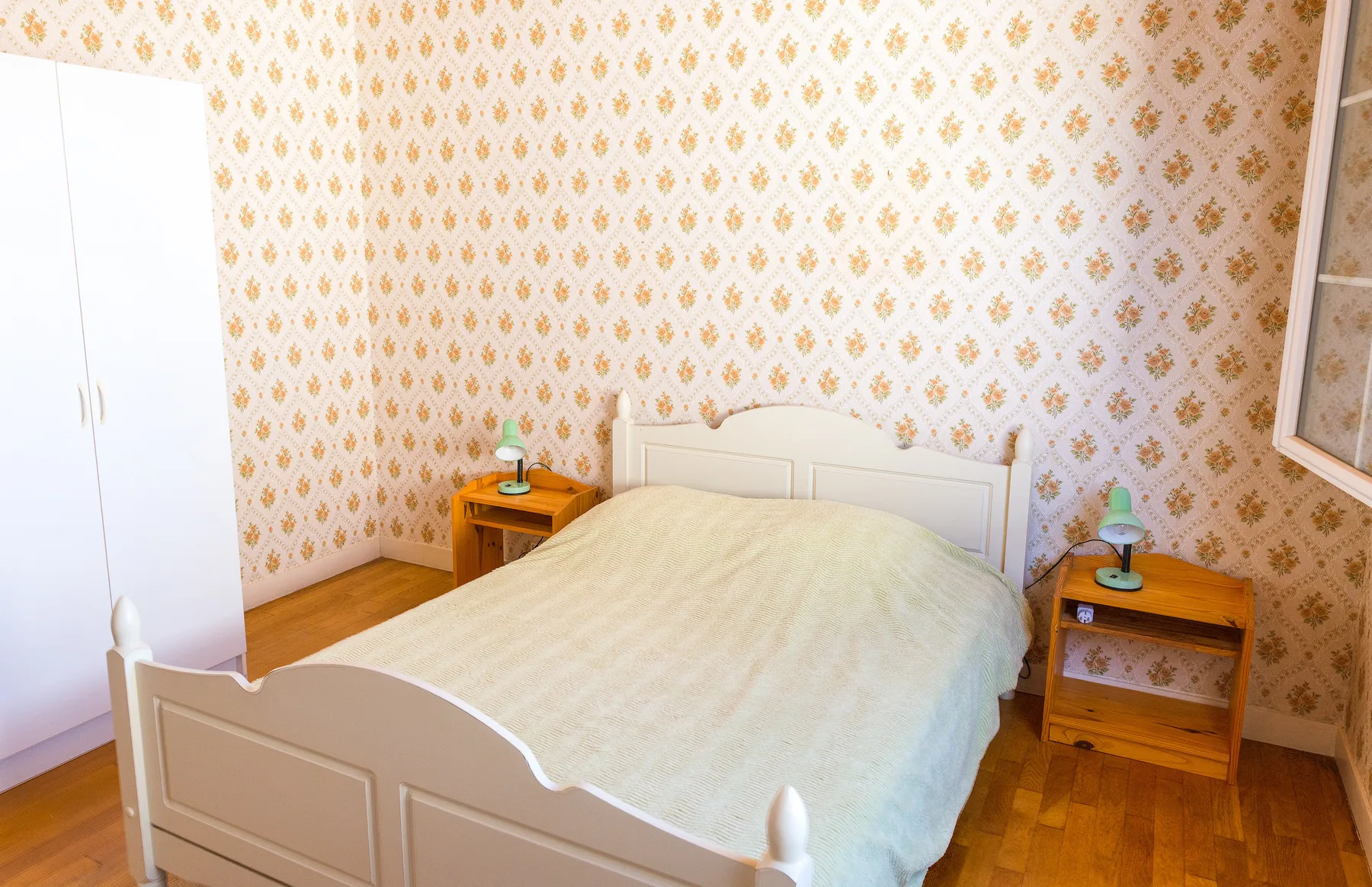 A bedroom with a bed between two bedside tables.