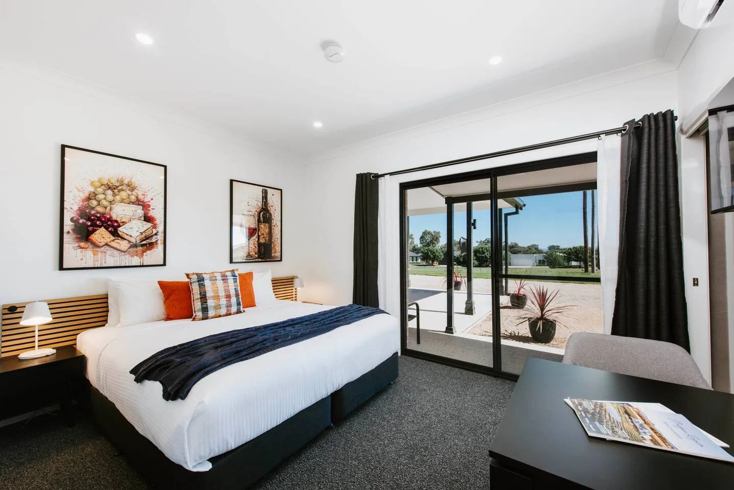Un dormitorio con una cama y puertas corredizas de vidrio que dan a un patio.