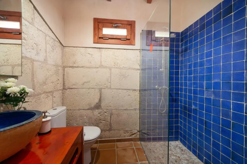 A bathroom with a tiled shower, sink, and toilet.