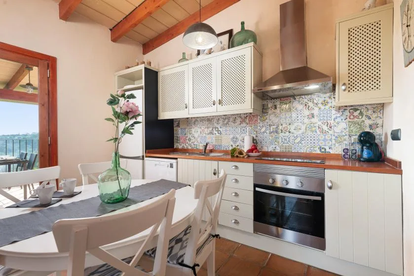 A kitchen and dining area with a table beside the counter and oven.