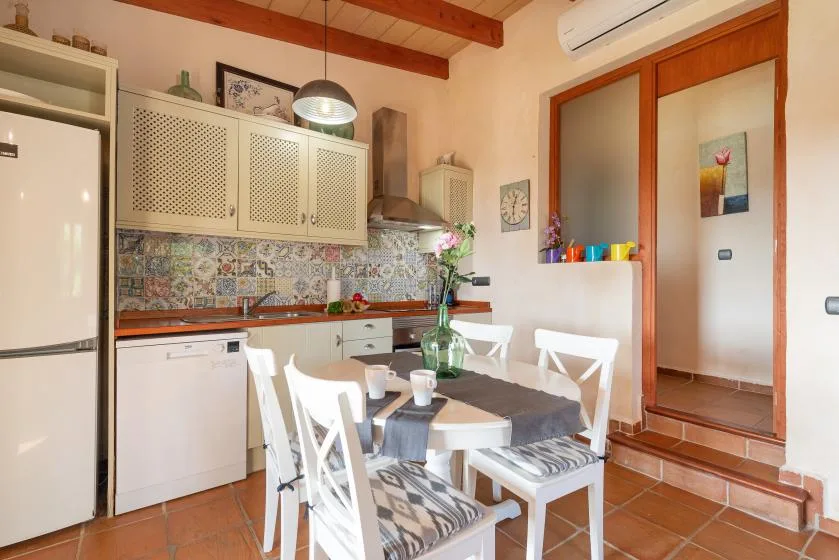 A kitchen dining area with a table, chairs, and patterned backsplash.