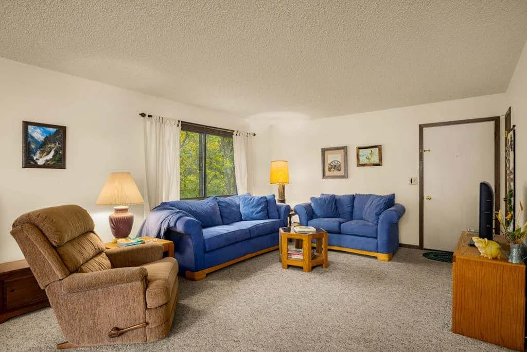 A living room with blue seating, a brown recliner, and a coffee table.