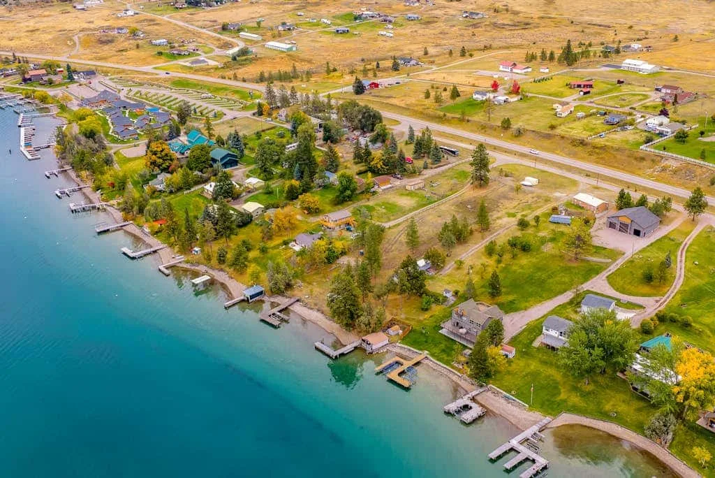 Aerial view of a lakeside settlement with docks along the shore.
