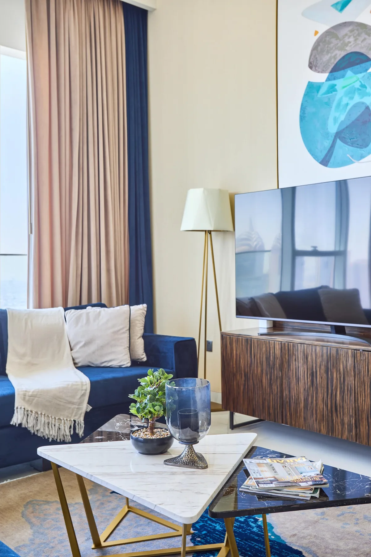 A living room with a blue sofa, a television, and a coffee table.