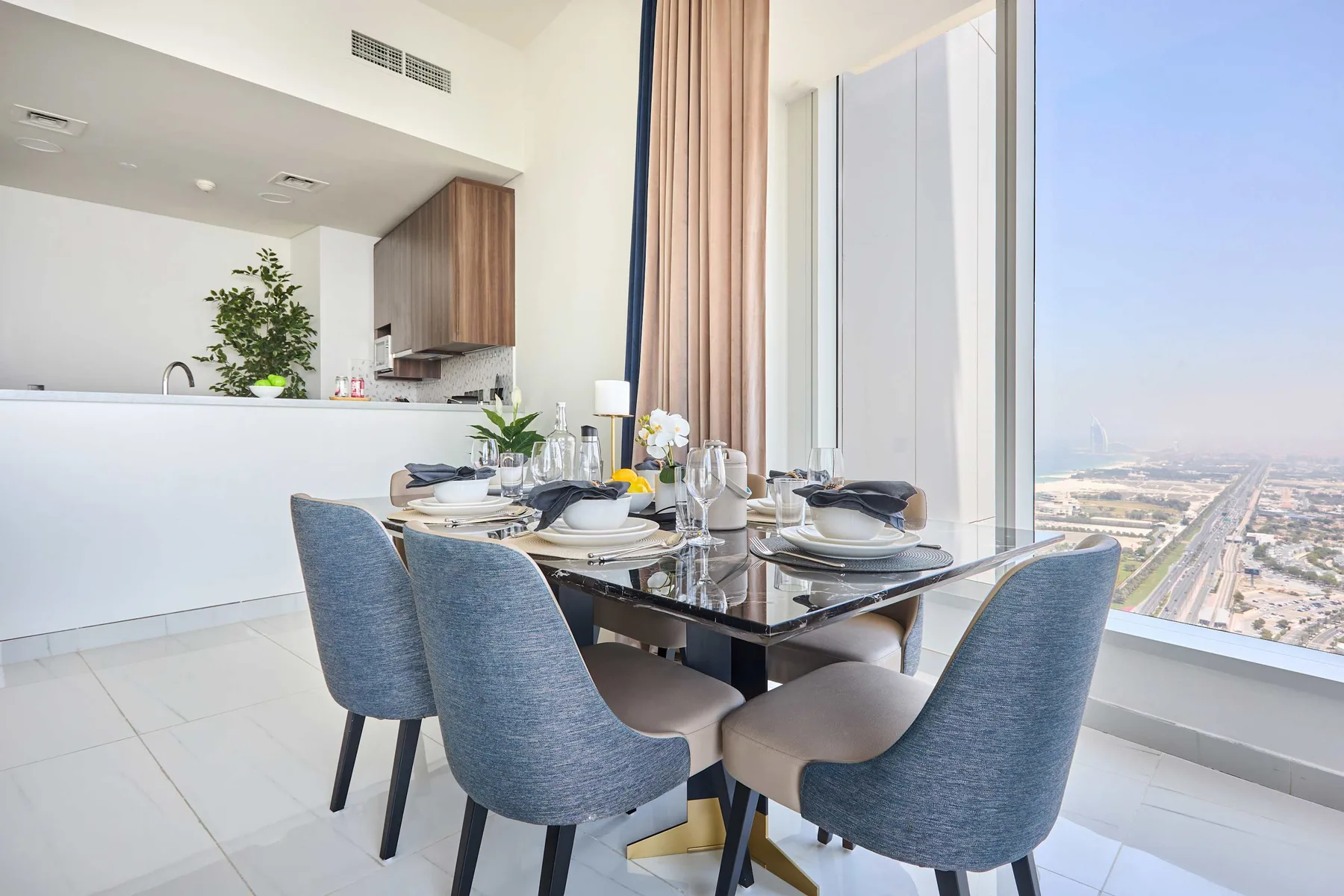 A dining area with a set table beside a large window overlooking the city.