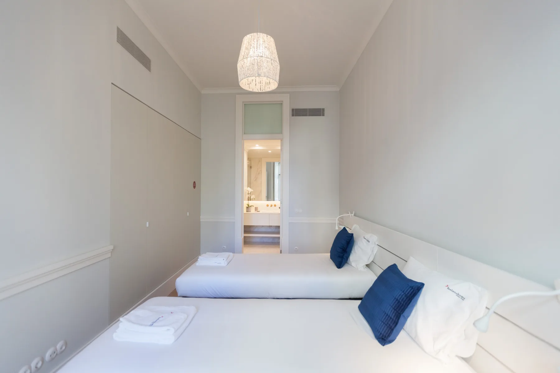 Un dormitorio con dos camas individuales y una puerta que da a un baño.