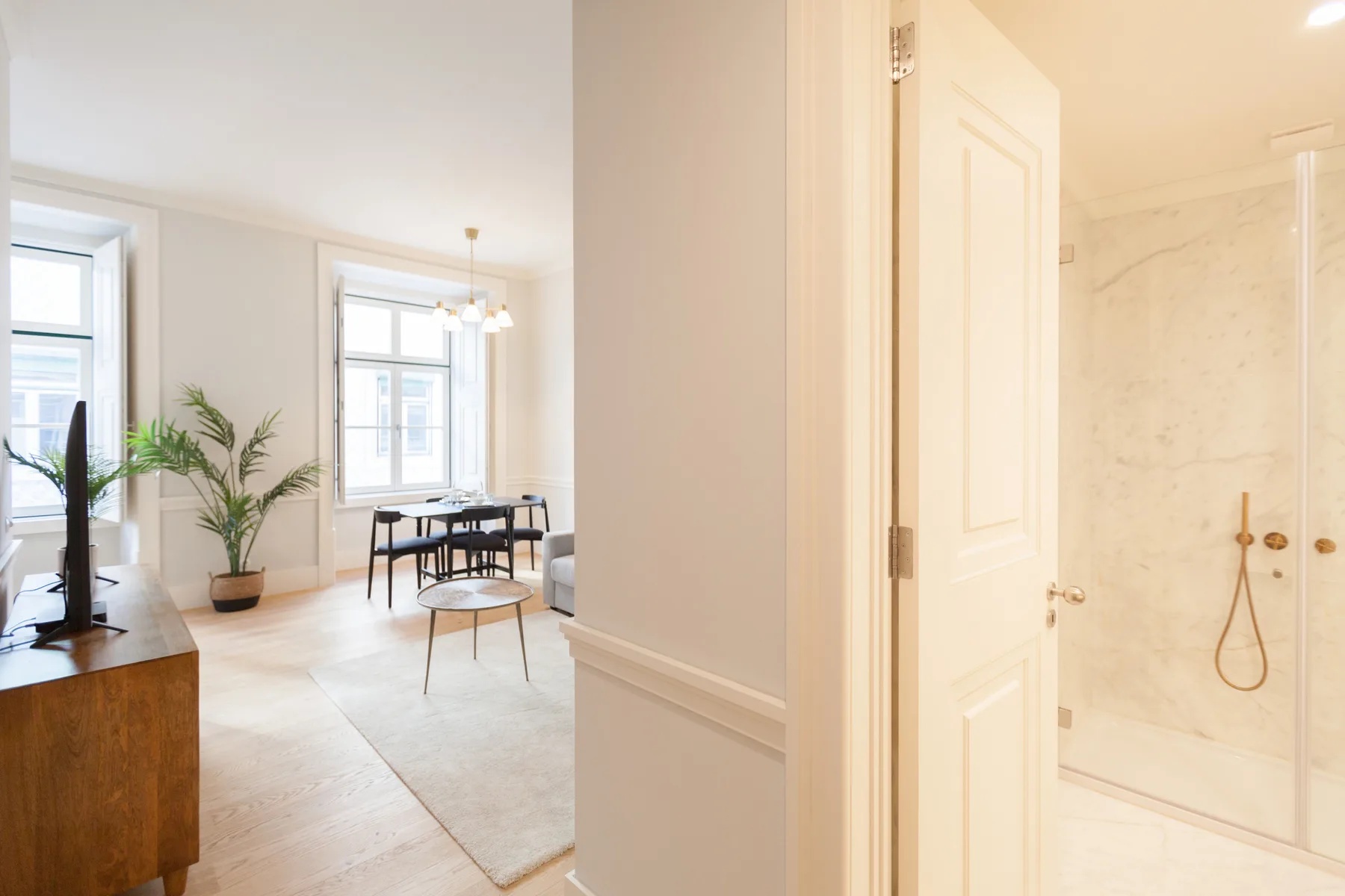 Interior de apartamento con comedor junto a una ducha de baño.