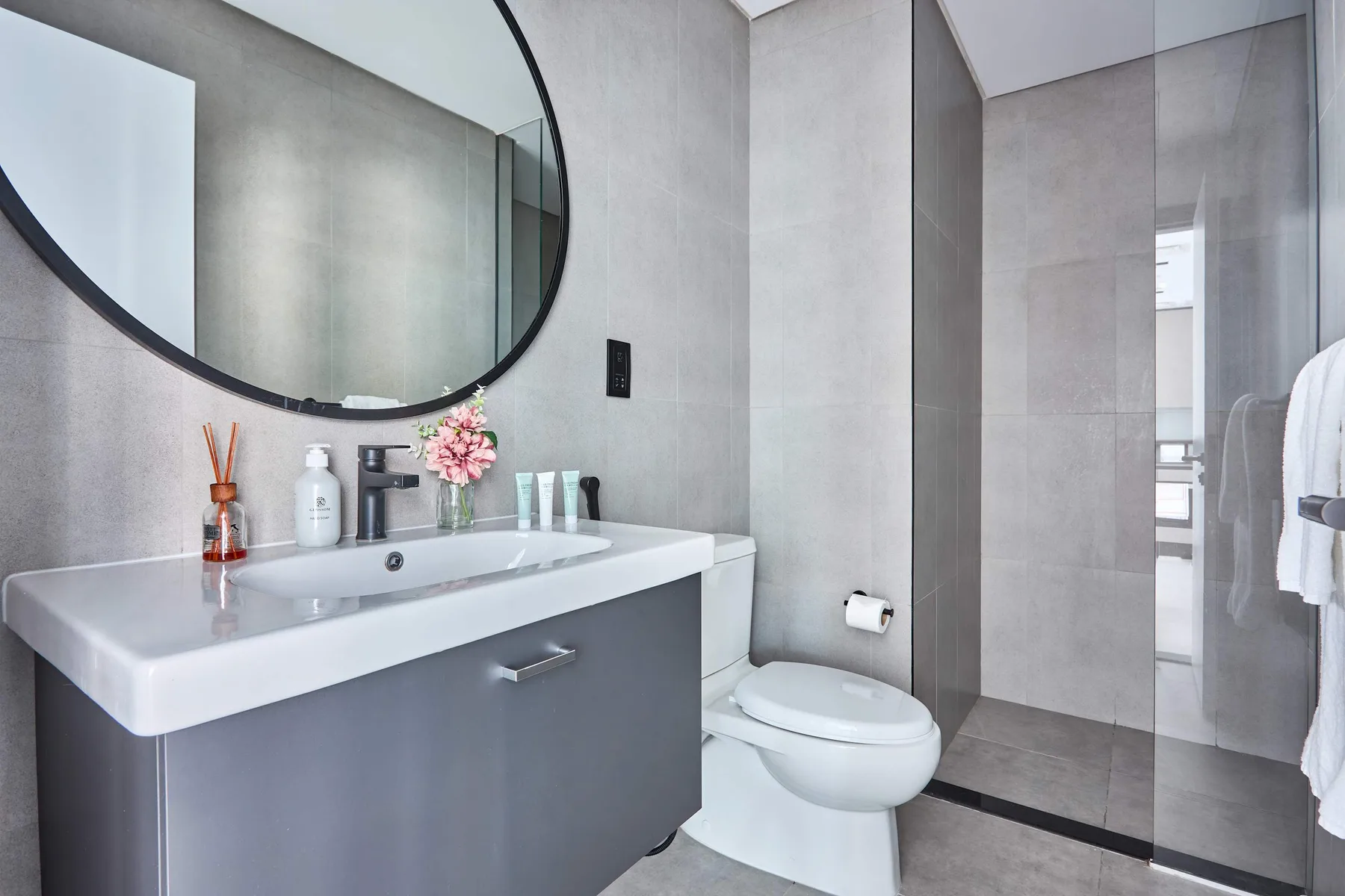 Un baño moderno con un lavabo amplio, un espejo grande y un inodoro.