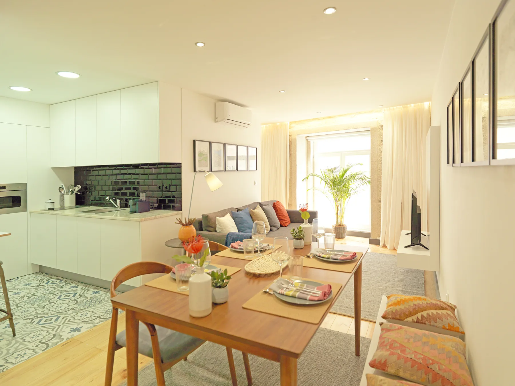 Sala-comedor de concepto abierto con cocina y una mesa preparada para comer.