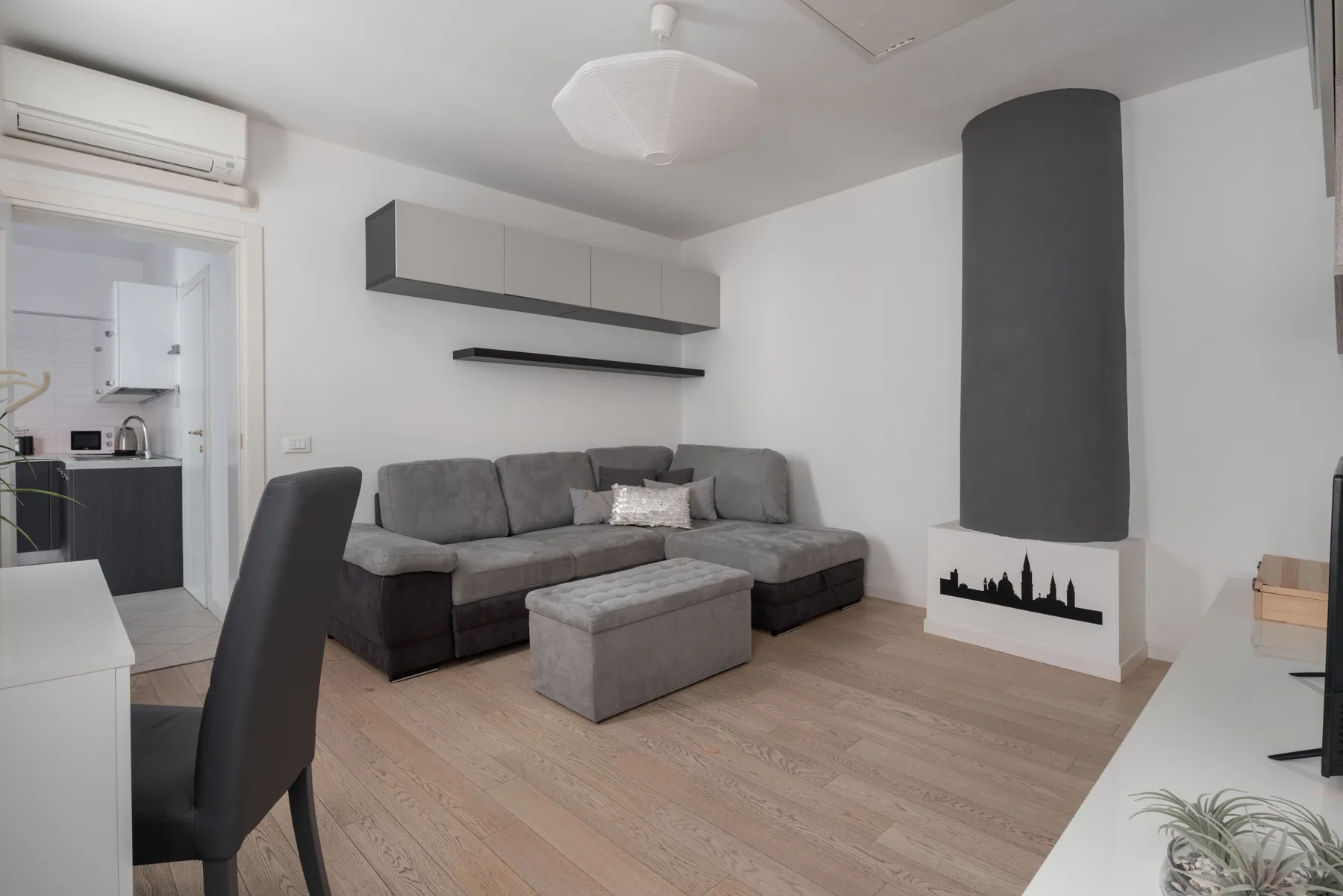 A living room with gray seating and a fireplace.