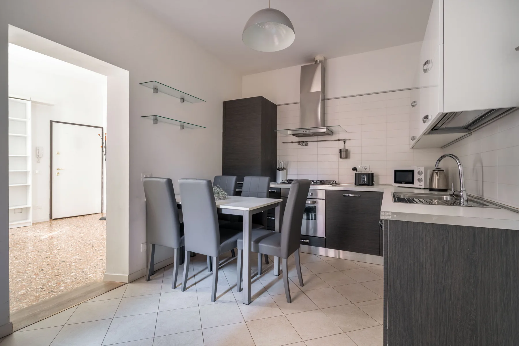 A modern kitchen and dining area with a table beside the countertop.