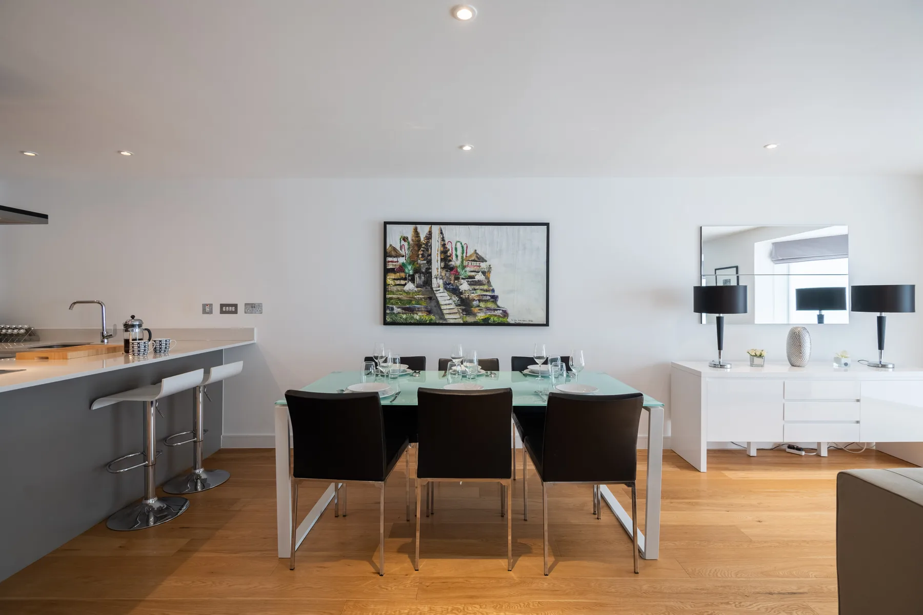 A dining area with a table and dark seating beside a kitchen counter.