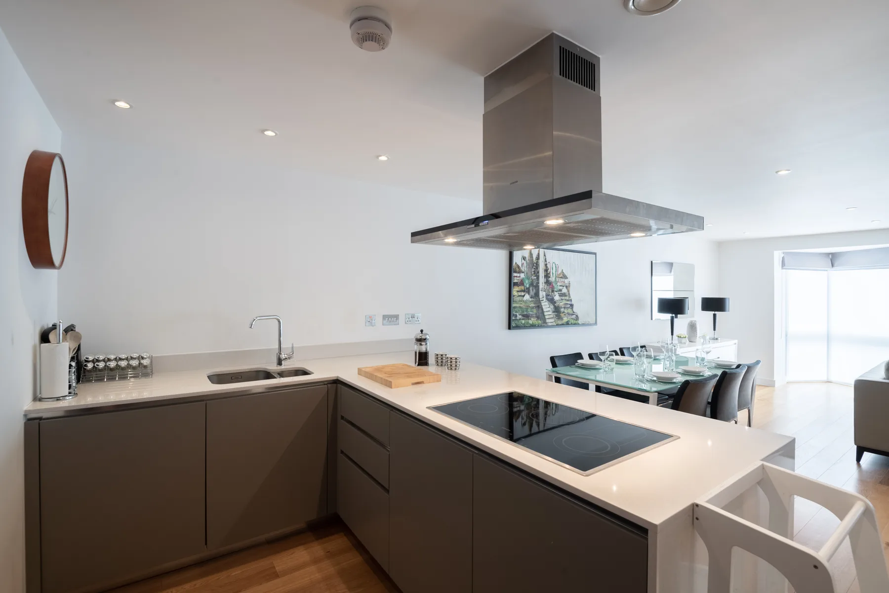 A modern kitchen with a central island and an open dining area.