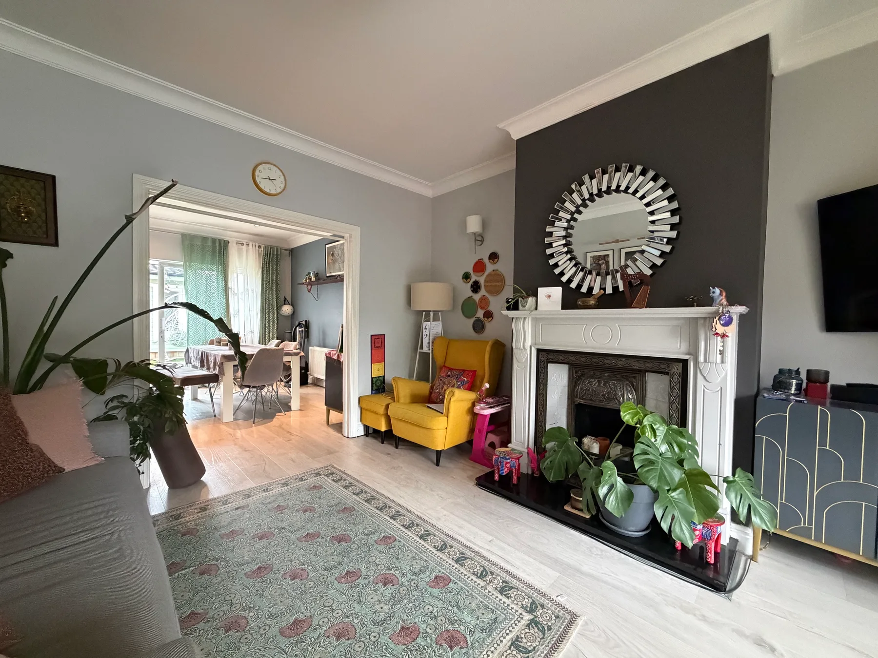 Living room with yellow seating, a fireplace, and plants.
