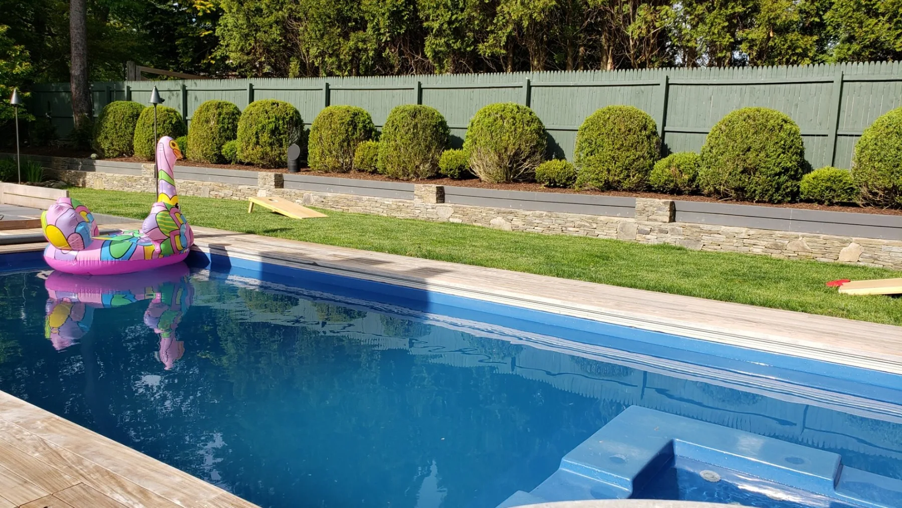Una piscina al aire libre con un flotador inflable colorido y escalones sumergidos.