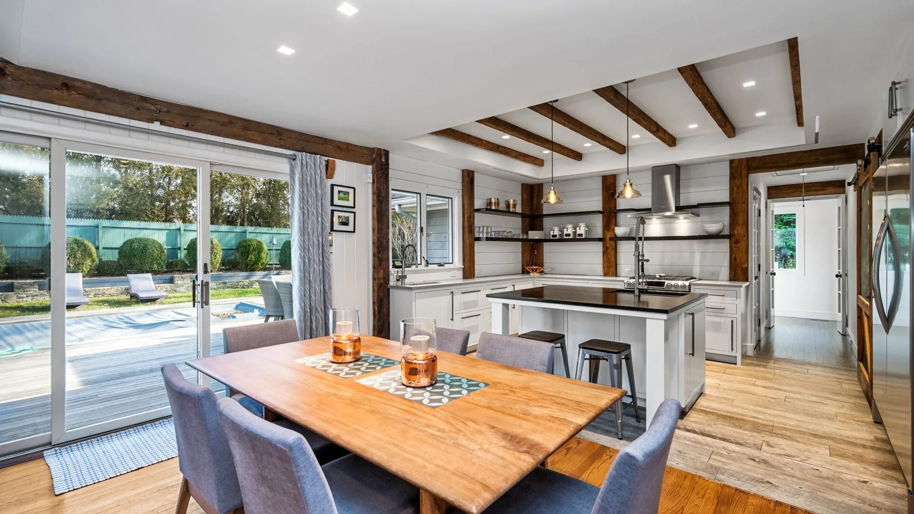Una cocina abierta con comedor, mesa de madera e isla.