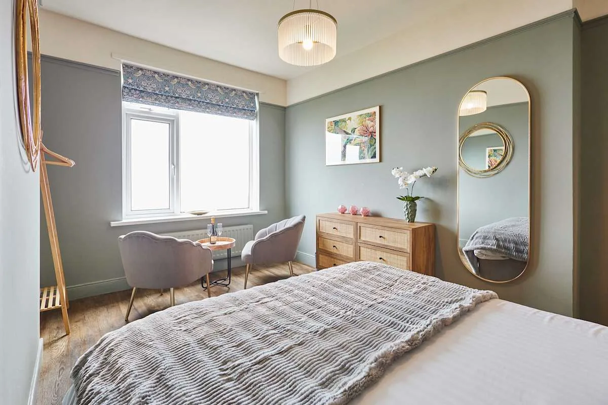 Un dormitorio con una cama, una ventana y una cómoda.