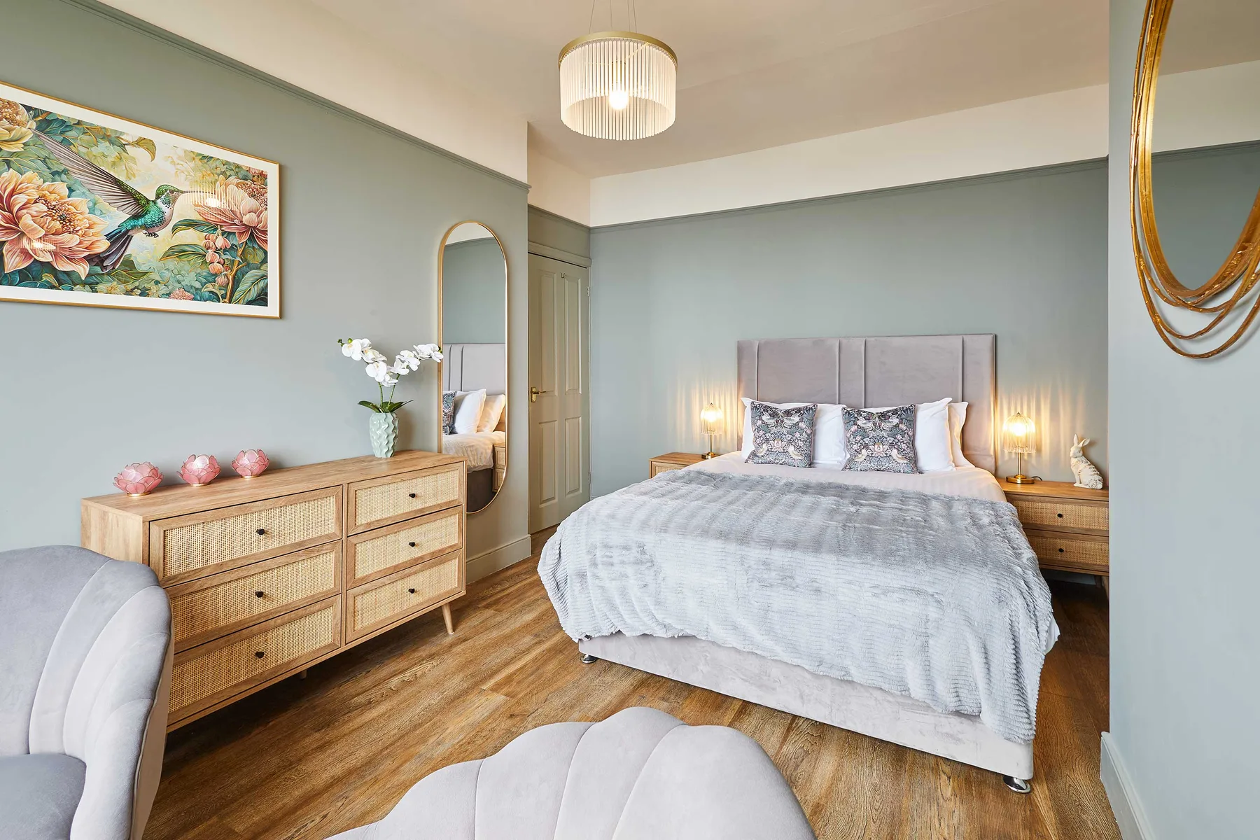 Un dormitorio con una cama, mesitas de noche y arte enmarcado en la pared.