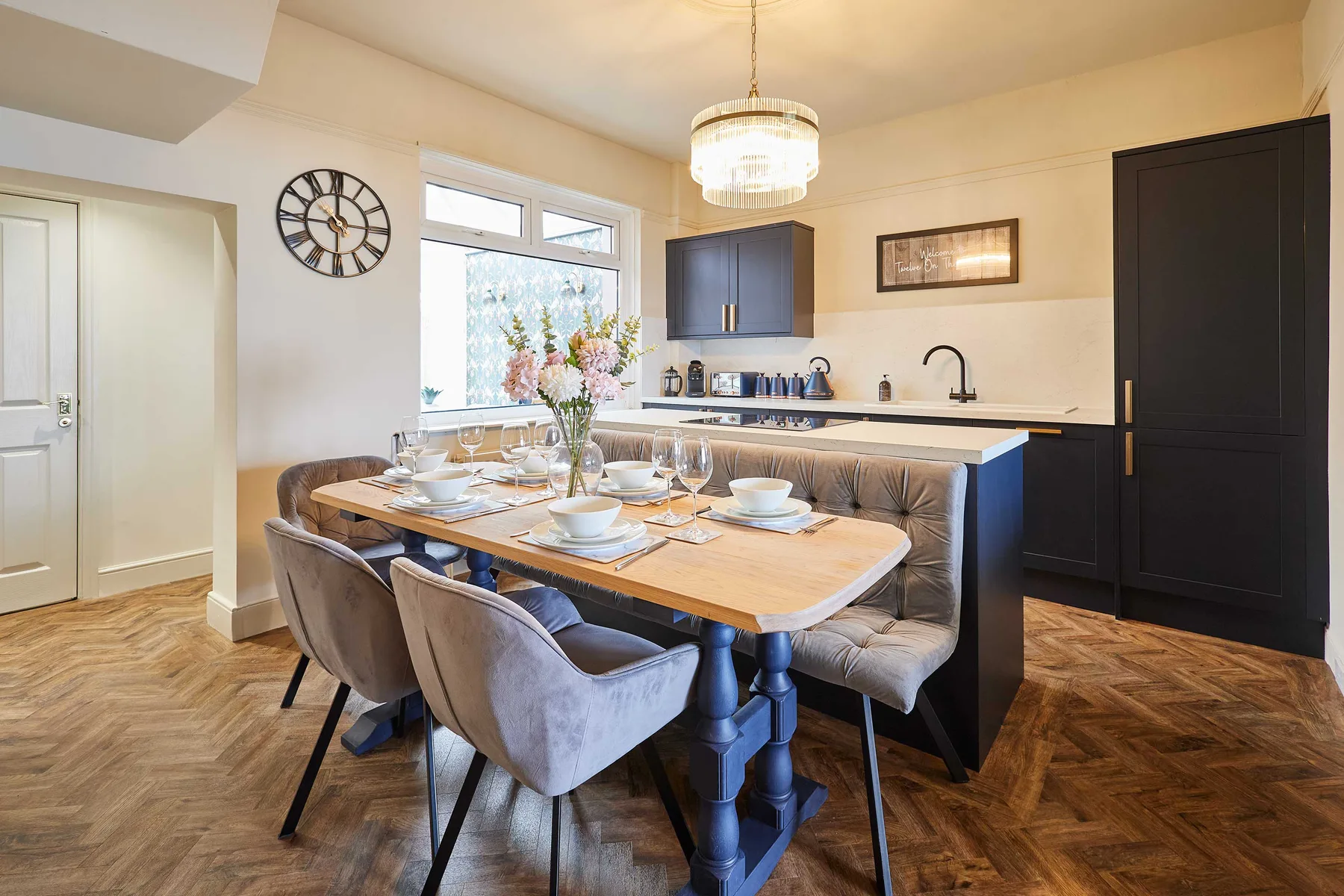 Comedor con la mesa puesta junto a una cocina compacta.
