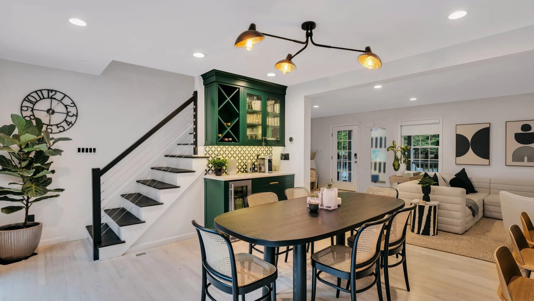 An open dining and living area with a table, seating, and a staircase.