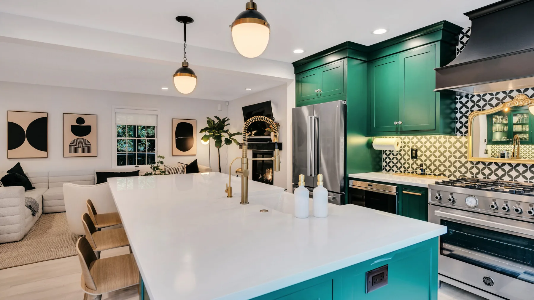 A modern kitchen with green cabinetry, a large island, and dining seating.