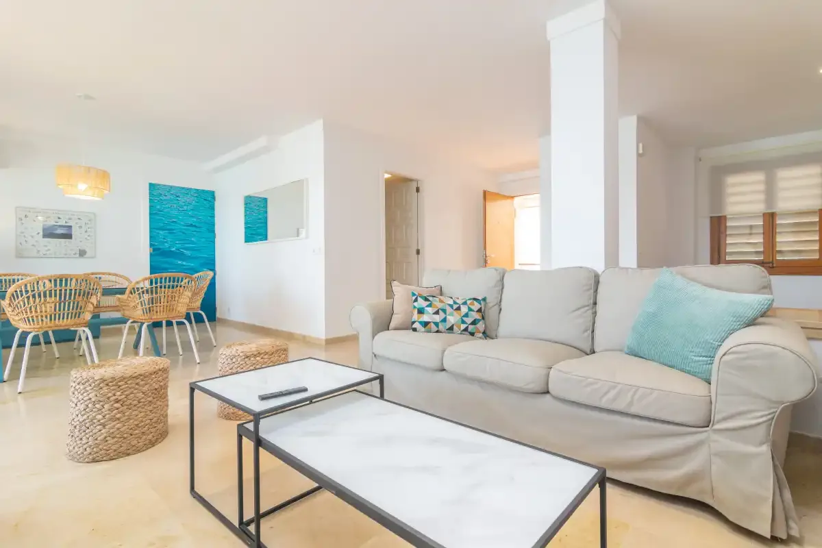 A bright living room with a seating area and two coffee tables.