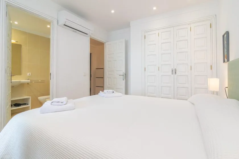 Bedroom with a neatly made bed and white paneled doors.