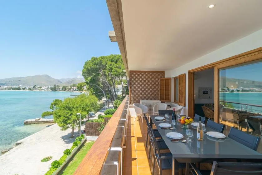 A covered outdoor dining area overlooks the water and surrounding hills.