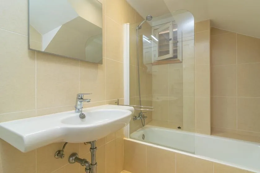 A tiled bathroom with a sink and bathtub.