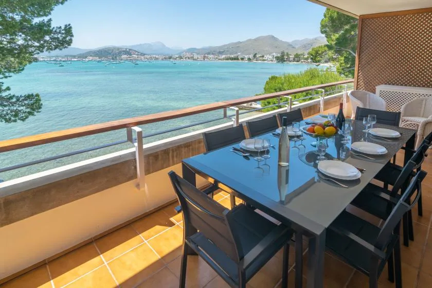 A waterfront terrace dining area with a set table overlooking the bay.