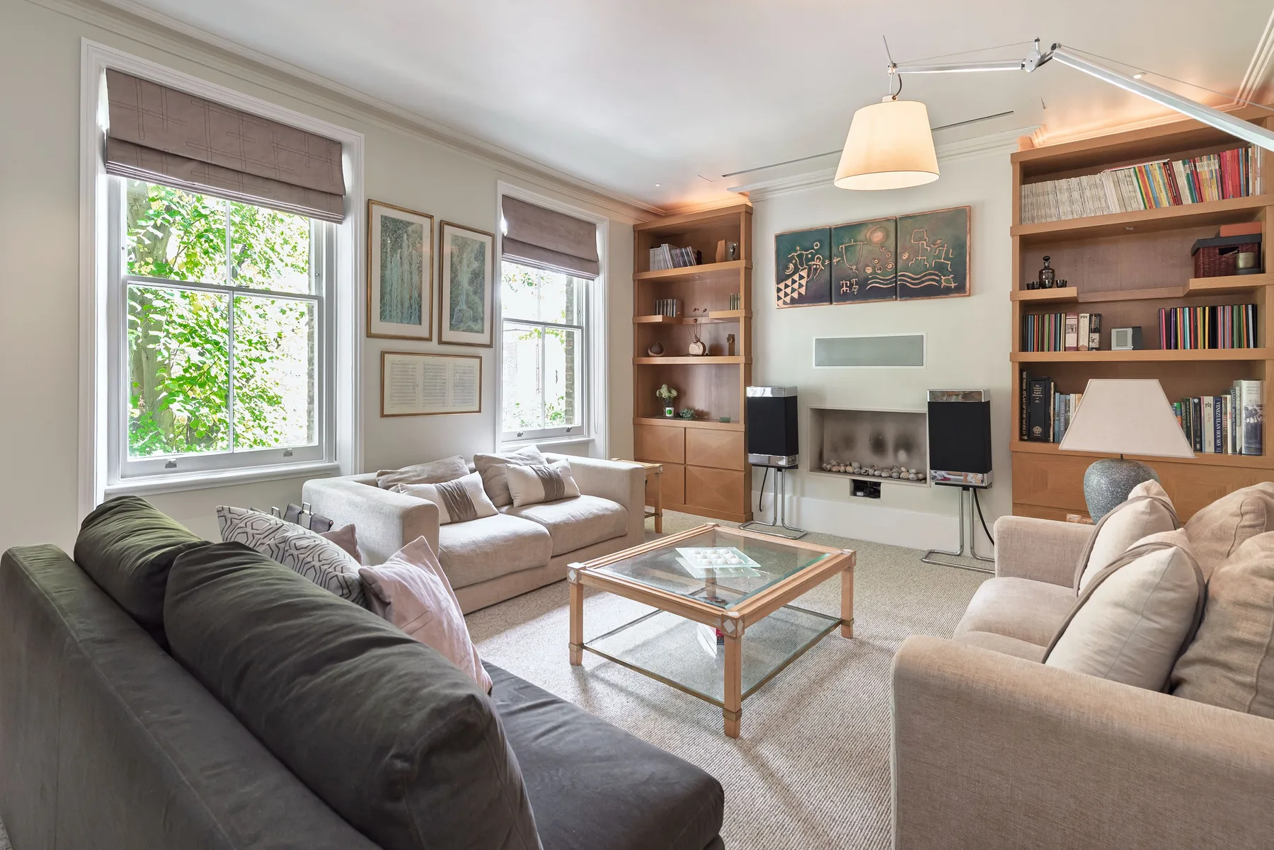 A living room with seating, a television, and built-in bookshelves.
