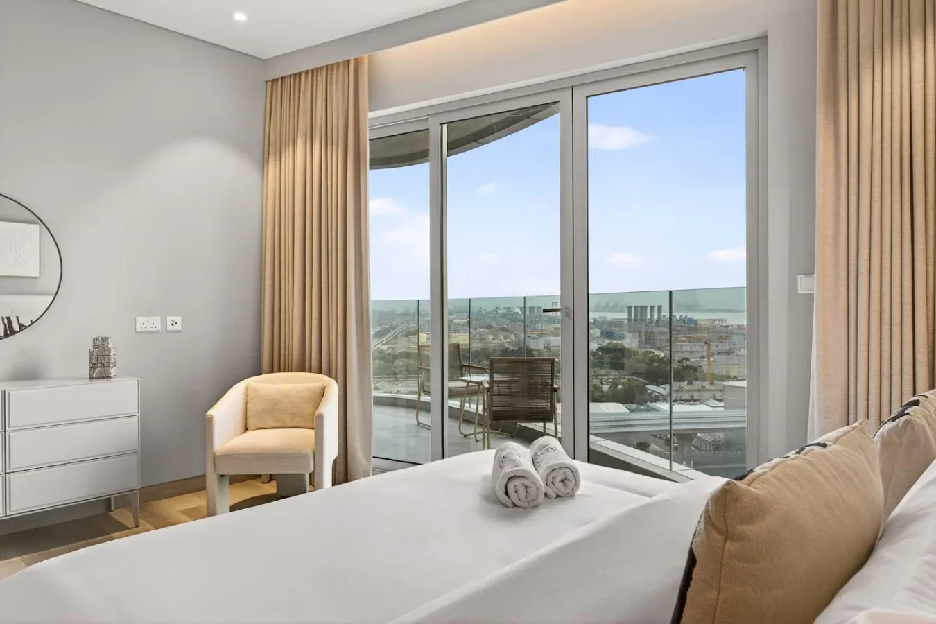 Un dormitorio luminoso con una cama y una gran ventana con vistas a la ciudad.