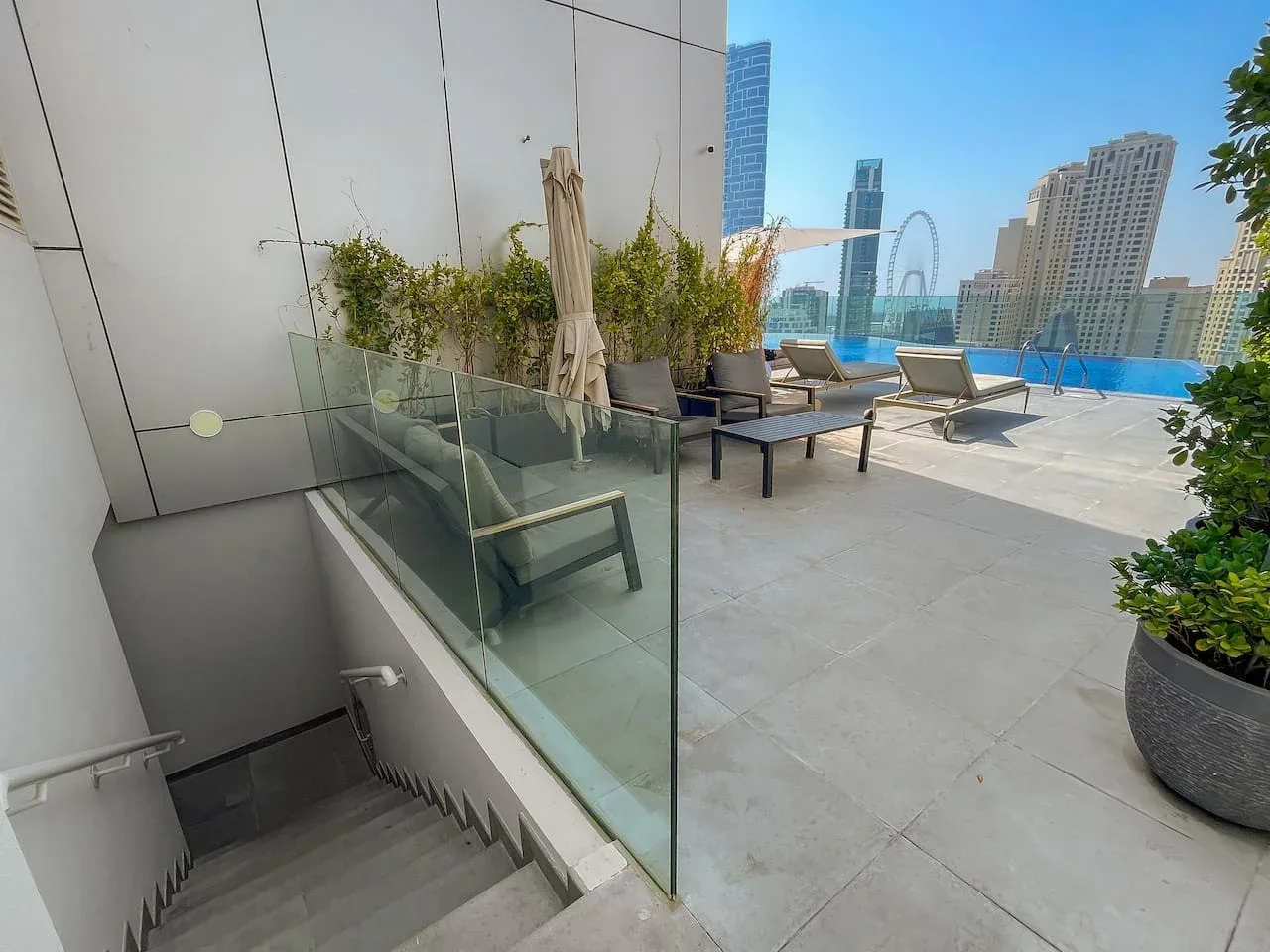 Una terraza en la azotea con asientos de descanso da a una piscina y al horizonte urbano.