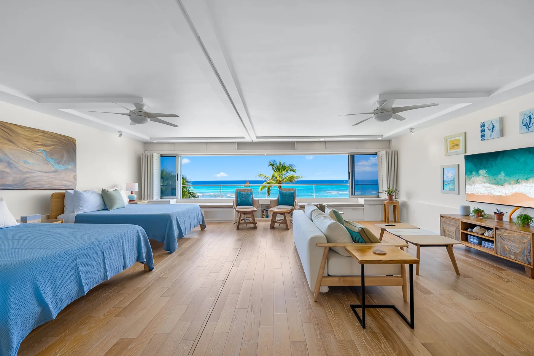A bright bedroom and sitting area opens onto a wide ocean view.