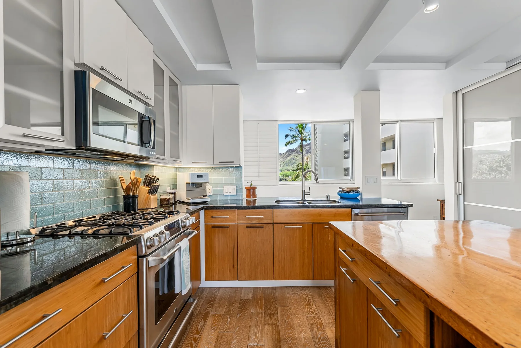 A bright kitchen with wooden cabinets, a central island, and a window above the sink.