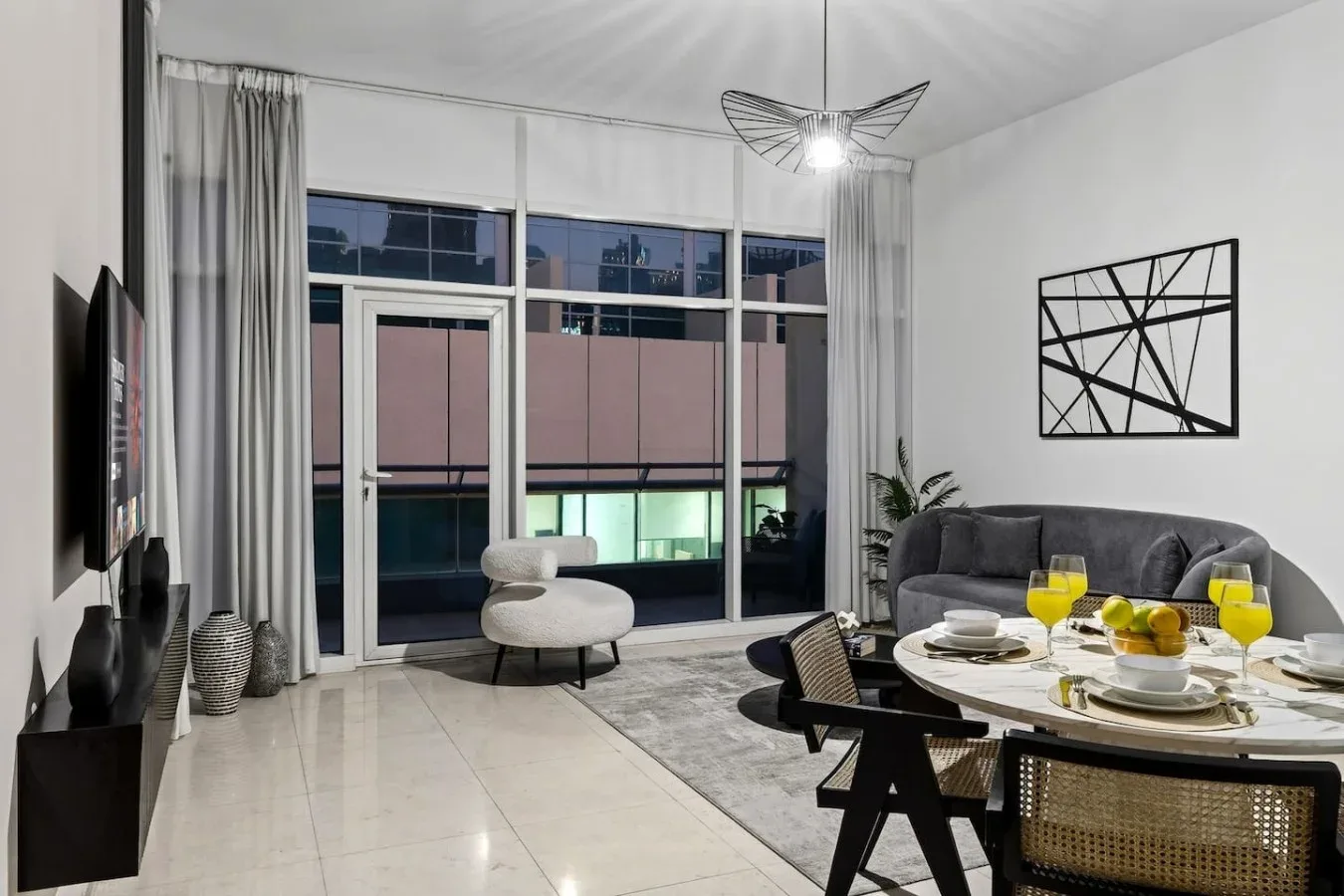 A modern living room with floor-to-ceiling windows and a dining table.