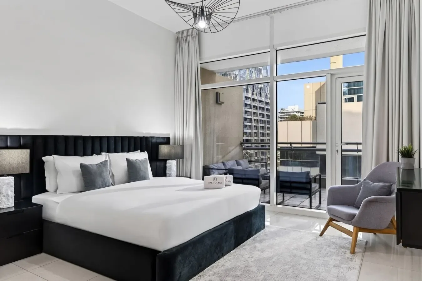 A bright bedroom with a large bed and glass doors opening onto a balcony.