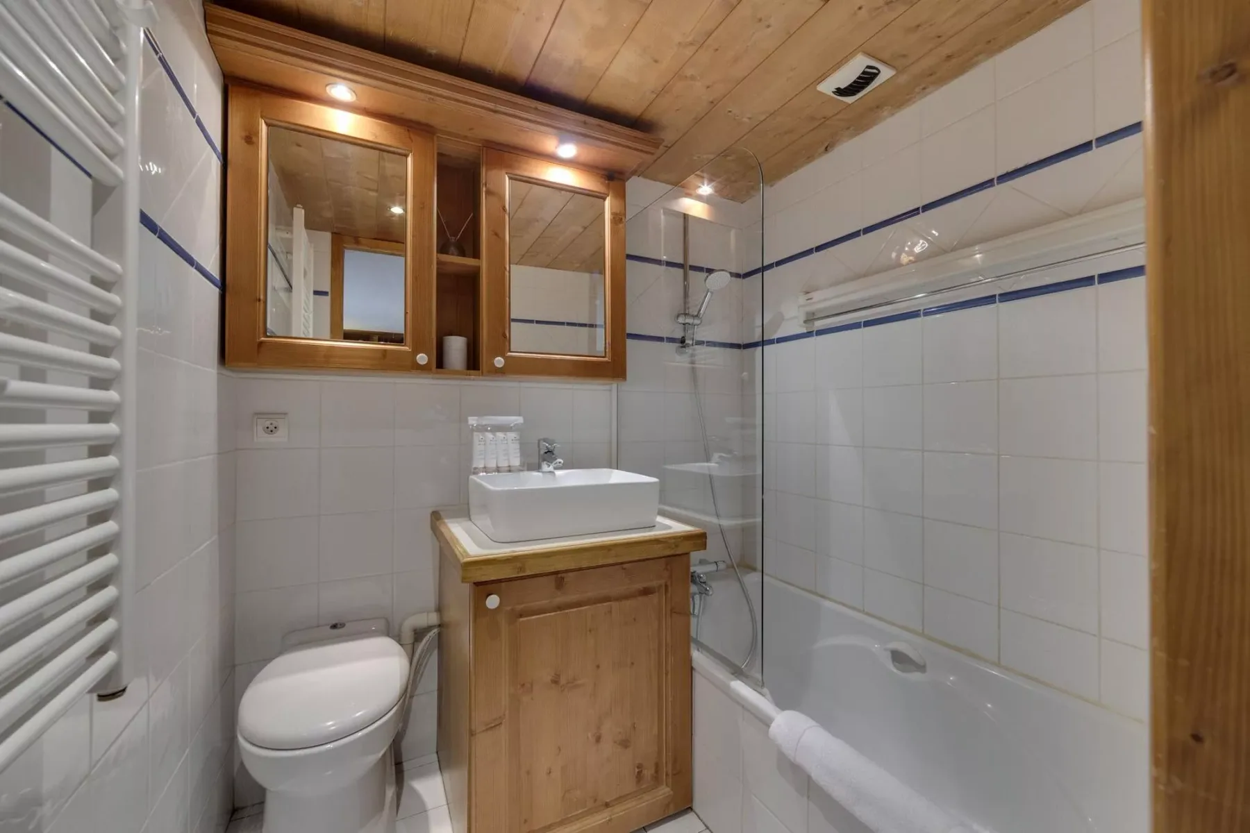 A tiled bathroom with a sink vanity and bathtub.