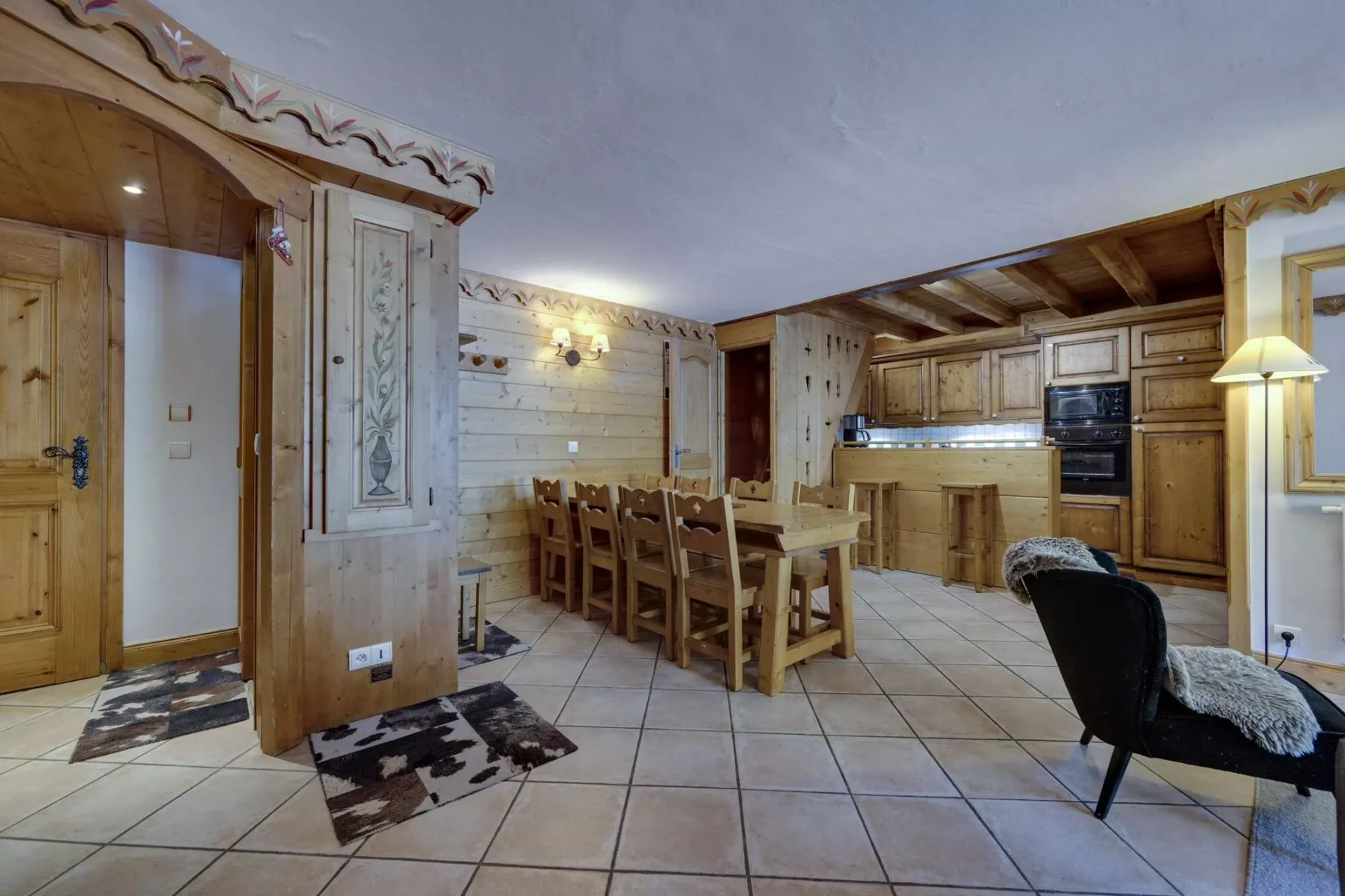 A wood-paneled dining and kitchen area with a long table and seating.