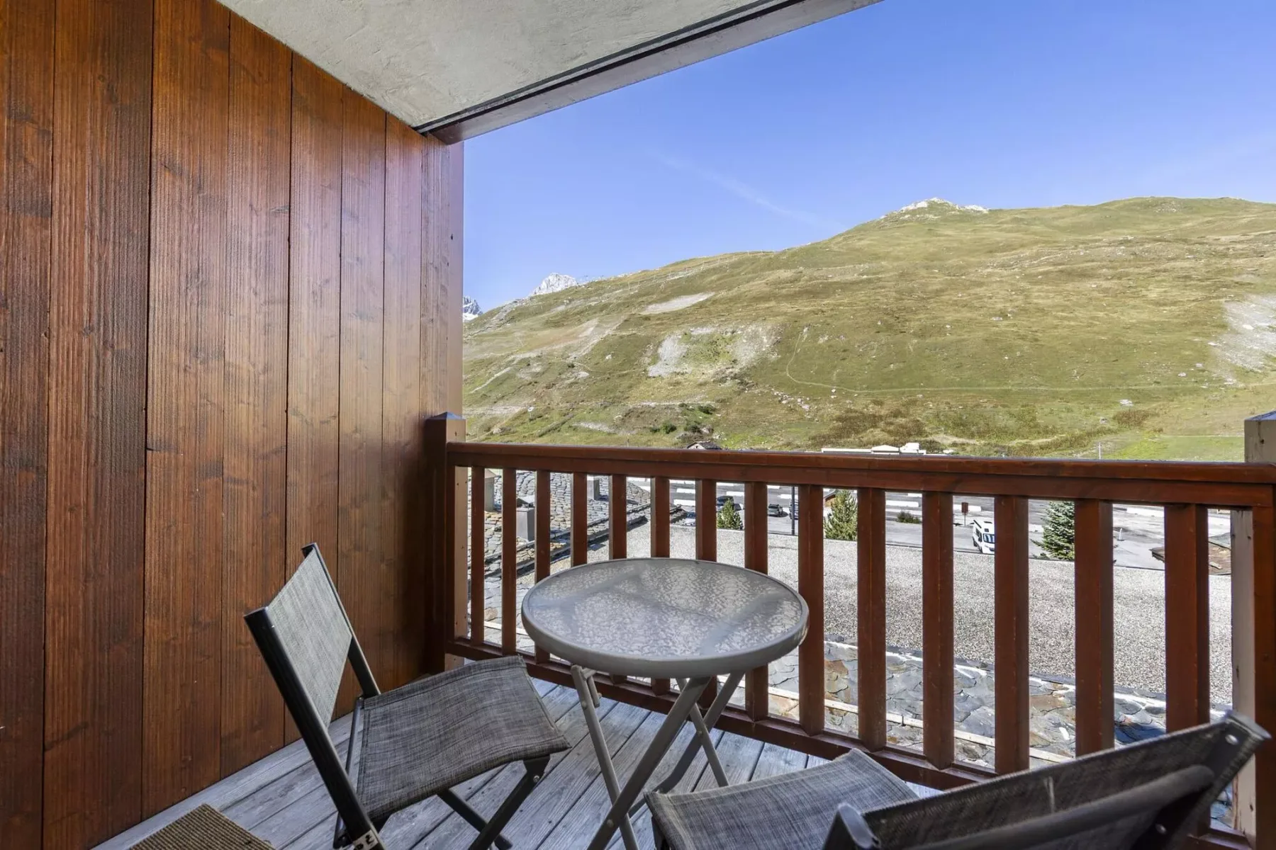 A balcony seating area overlooks a rocky mountain landscape.