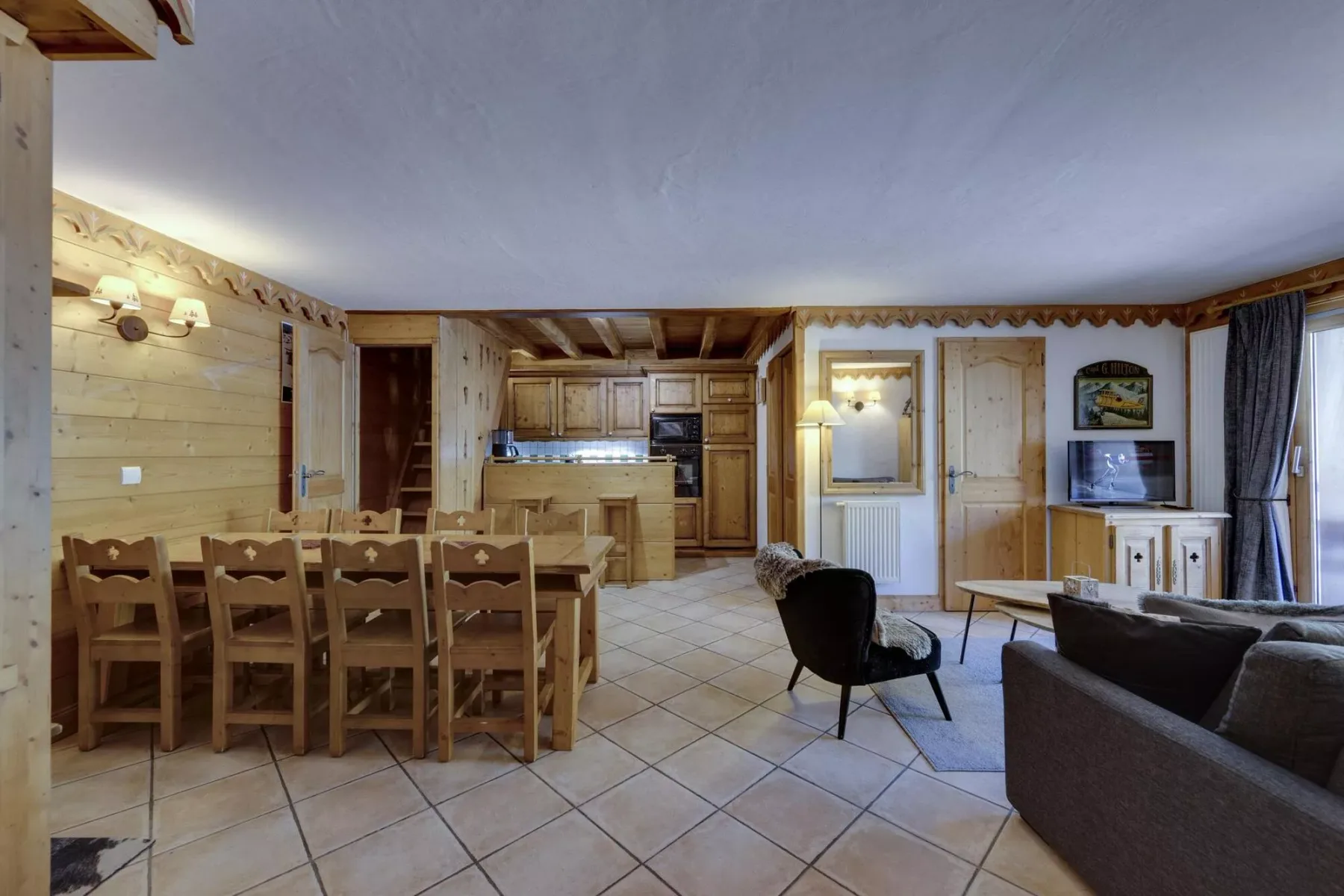 A combined living and dining room with a wooden dining table and seating area.