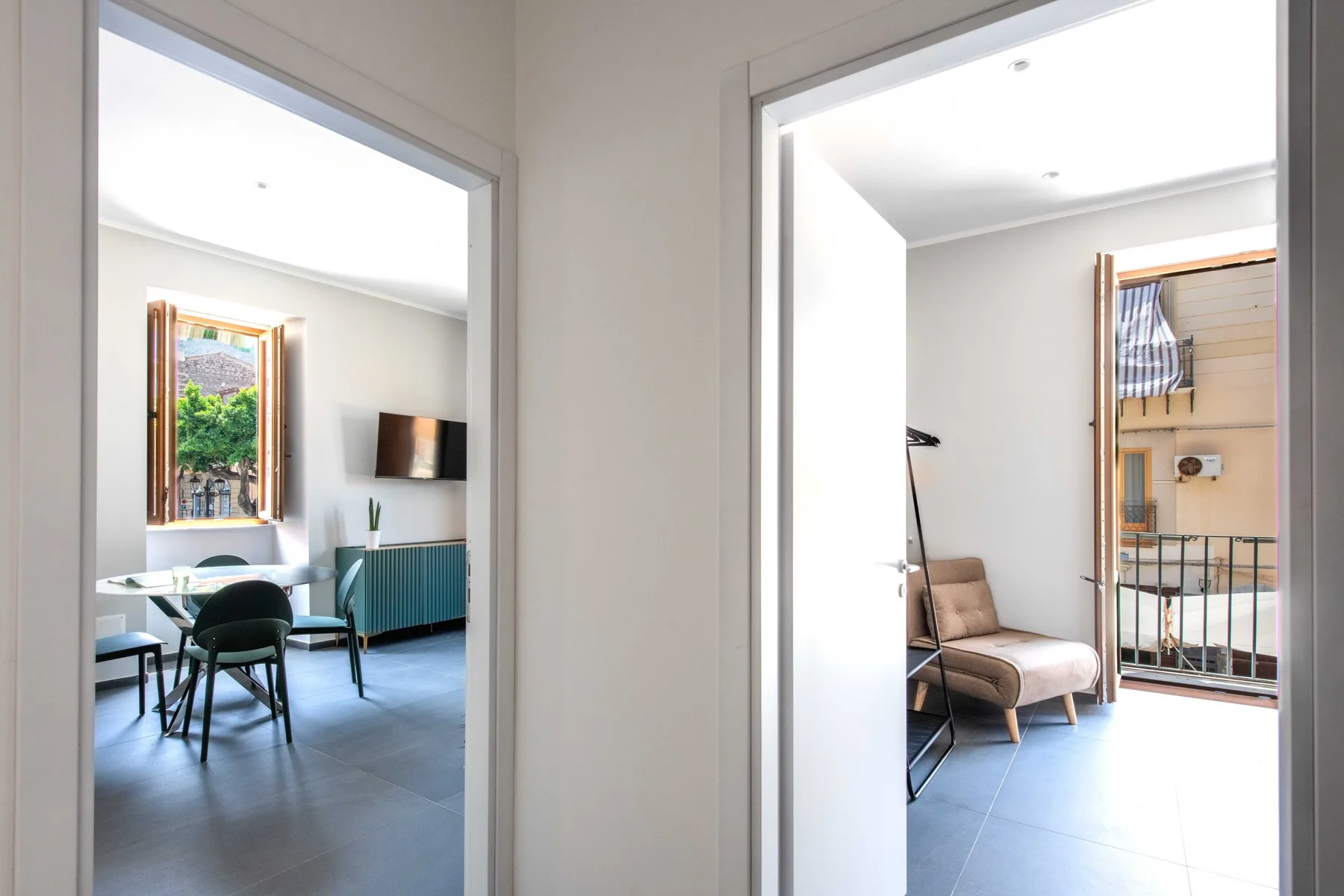 An interior hallway opens onto a dining area and a bedroom with seating.