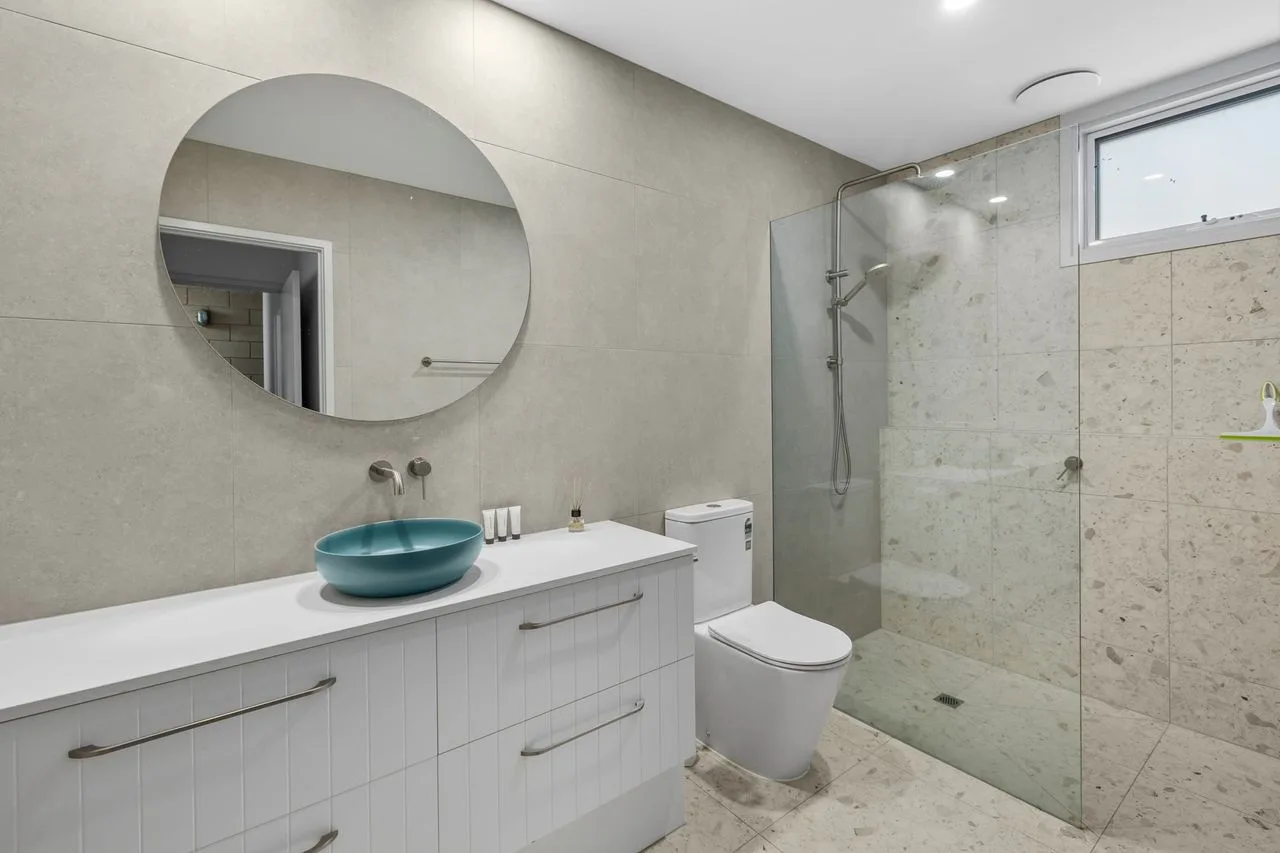 A modern bathroom with a glass shower and a vanity.